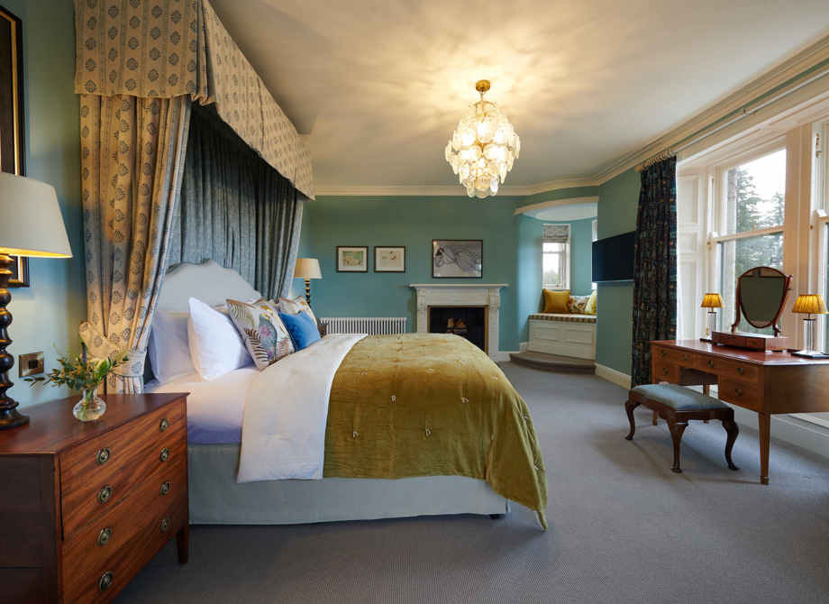 Interior view of the Cromlix Hotel's Turret Suite with a luxurious bed, soft lighting, and architectural details.