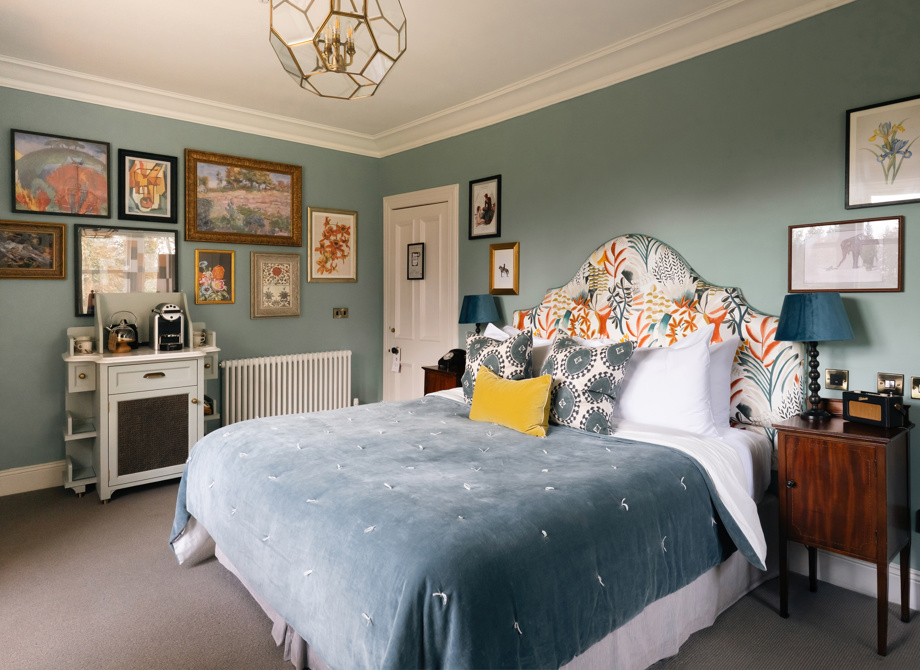 A bedroom in the Estate Room at the Cromlix Hotel in Dunblane, featuring a blue velvet bedspread and a green wall.