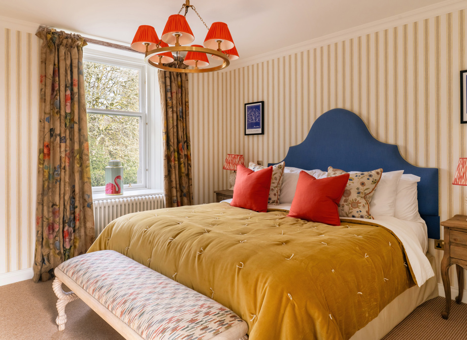 Elegant bedroom in a Deluxe Suite at the Cromlix Hotel in Dunblane, featuring a blue headboard and gold accents.
